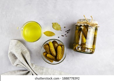 Pickled Cucumbers In A Glass Jar And Bowl, Pickle Juice In Glass On A Light Background.  Homemade Fermented Or Marinated Cucumbers.