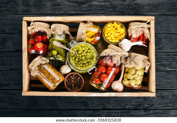 Pickled foods in cans. Stocks of food. Top\
view. On a wooden background. Copy\
space.