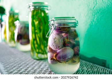 Pickled onions and hot peppers in a glass