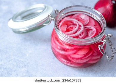 Pickled red onions in glass jar on a gray background. Appetizer, condiment or topping. Healthy fermented food. . High quality photo