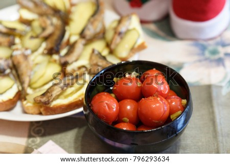 Pickled tomatoes in a jar on the table of pine boards.