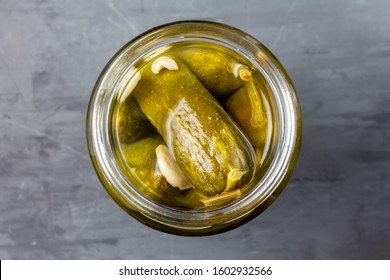 Pickled Whole Cucumbers In A Glass Open Jar On The Kitchen Table. View From Above