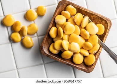 Pickled yellow Lupin Beans in bowl on kitchen table. Top view.