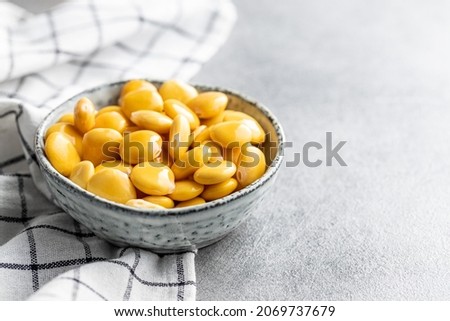 Pickled yellow Lupin Beans in bowl on kitchen table.