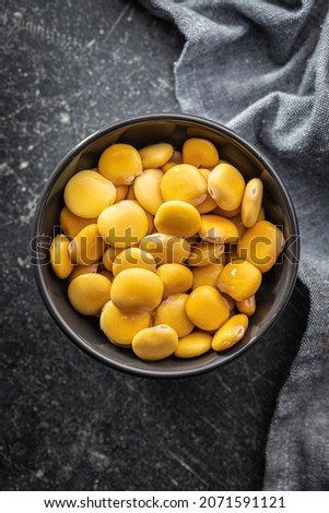 Pickled yellow Lupin Beans in bowl on kitchen table. Top view.