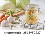 Pickling cabbage with carrot at home on table. Prepare homemade sauerkraut or fermented cabbage with carrot.