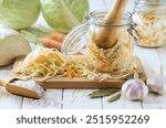 Pickling cabbage with carrot at home on table. Prepare homemade sauerkraut or fermented cabbage with carrot.