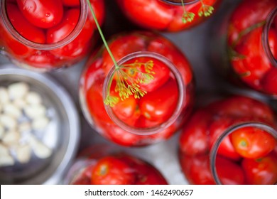 Pickling (canning) The Tomatoes. Glass Jars With Tomatoes. Garlic In A Metal Plate. 