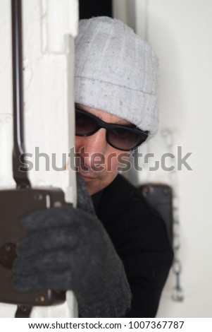 Picklock peeping out of a door