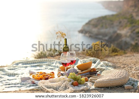 picknick outdoors with fruits and wine by sea in naure