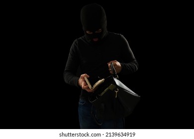 Pickpocket With A Black Balaclava Looking For Money And Wallet Inside A Stolen Purse During The Night 