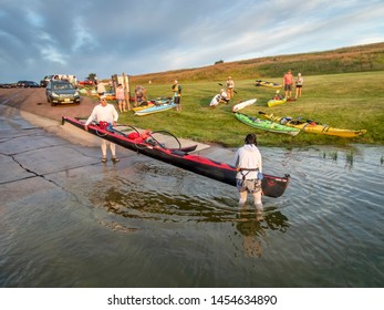 Pickstown, SD, USA - July 13, 2019: A couple launching their tandem outrigger canoe on MIssouri River below Fort Randall Dam for 50 mile river race.