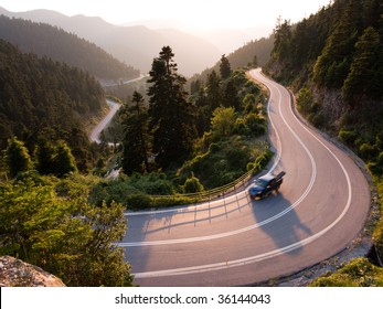 pickup crosses mountain road winding in twilight - Powered by Shutterstock