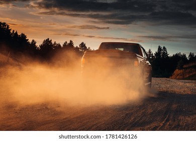 Pickup truck car in motion at country road with clouds of dust