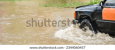 Pickup truck was driving through flooded roads where floods are caused by heavy rains and cause vehicle undercarriage and engine damage, concept for car insurance.