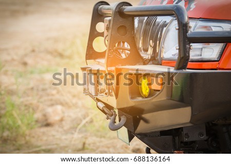 Pickup truck a font of 4 WD adventure off road font view has Bumper, turn signal, spotlight, towing, hook, headlights.