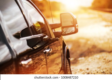 Пикап грузовик бездорожья вождения во время живописного заката. Тяжелый груз тянет на сельской дороге.