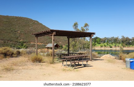 The picnic area with trellis cover and picnic tables at Lake Poway in Poway, California USA.