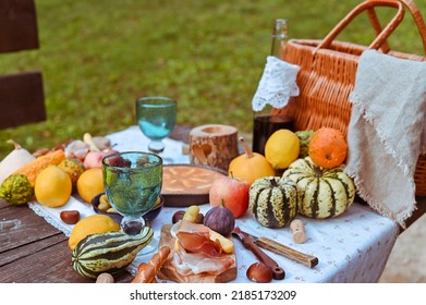 picnic in autumn park. Food, drinks, picnic basket on a wooden table in the garden. Cozy lunch atmosphere. Pumpkin, pie and wine on the table. High quality photo