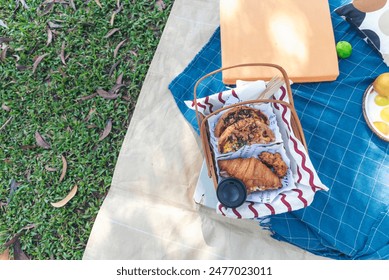 Picnic basket croissant bread Bacon egg cheese brunch box food coffee cup orange juice in wood wicker box on red Blanket. whole Wheat bread bakery fruit food and drinks green park outdoor lifestyle - Powered by Shutterstock