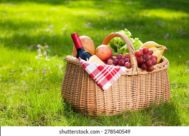 Picnic basket with food on green sunny lawn. - Powered by Shutterstock