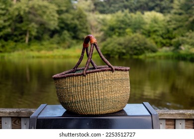 Picnic basket on a deck by a pond in a summer time picnic - Shutterstock ID 2253512727
