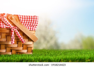 Picnic basket on the grass on the background of nature. Relaxation and summer mood. Departure for a picnic for the weekend or vacation.