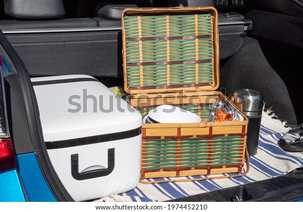 Picnic Basket with Snacks and a Cooler in the Trunk\
Boot of a Car