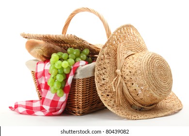 Picnic basket and straw hat isolated on white background.