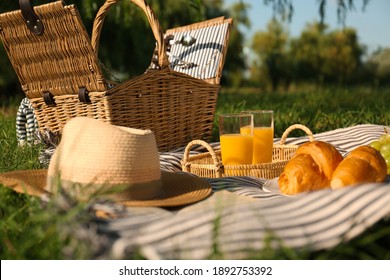 Picnic Blanket With Delicious Food And Juice Outdoors On Sunny Day