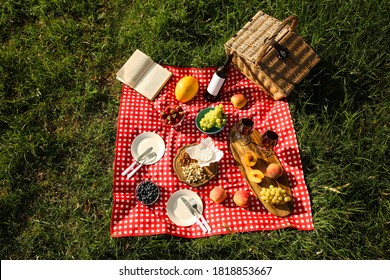 Picnic Blanket With Delicious Food And Wine On Green Grass, Top View