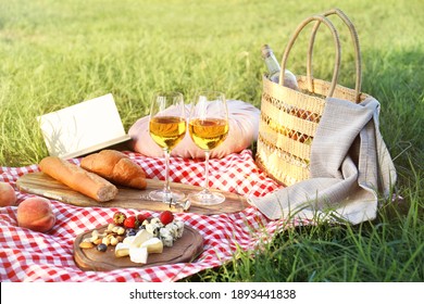 Picnic Blanket With Delicious Food And Wine In Park On Sunny Day