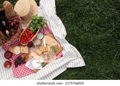 Picnic blanket with different products on green grass, top view. Space for text - Powered by Shutterstock