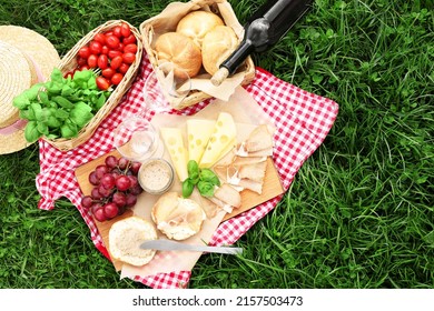 Picnic Blanket With Wine And Food On Green Grass, Top View