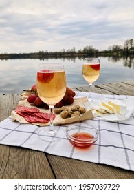 Picnic during Under dramatic storm sky with wine, grapes and cheese.