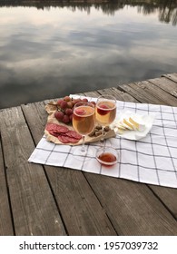 Picnic during Under dramatic storm sky with wine, grapes and cheese.