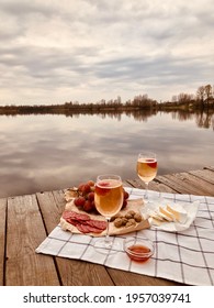 Picnic during Under dramatic storm sky with wine, grapes and cheese.