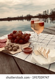 Picnic during Under dramatic storm sky with wine, grapes and cheese.