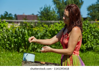 Picnic, Eating And Cooking Concept. A Woman 30-35 Years Old Cleanses The Eggs From The Shell. The Process Of Cooking Salad.