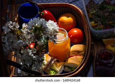 Picnic At Home. Picnic Indoor Concept. Fruits, Juice, Sandwiches And Flowers. Picnic Bag.