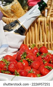 Picnic refreshments with handpicked strawberries, baguette and champagne. Healthy red strawberries are sweet and juicy.