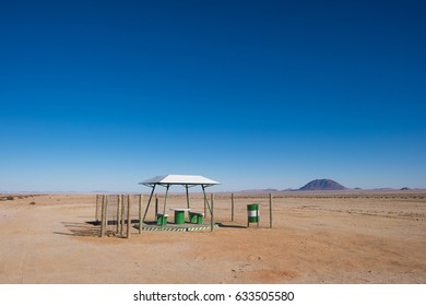 Picnic Rest Area With Benches, Table And Garbage Can In The Middle Of Nowhere Along The B4 Road From Aus To Luderitz In The Namib Naukluft Desert, Namibia, Africa. 