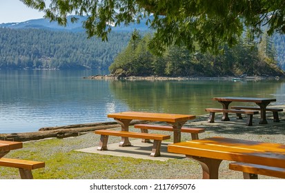 Picnic site in summer time. Lake shore bench landscape view. Travel photo, nobody, selective focus.