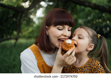 Picnic In Summer Park. Close Up Portrait Of Single Mom With Little Daughter Is Engaged In Eating Cake Resting Outdoor.