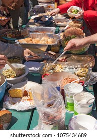 A Picnic Table Full Of Food At An Outdoor Picnic Potluck Community Lunch.