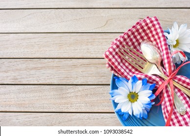 Picnic Table Setting In Red White And Blue Colors For July 4th Celebration On Wood Board Background Table With Room Or Space For Copy, Text Or Your Words.  A Horizontal Flatlay Photo From Above View.