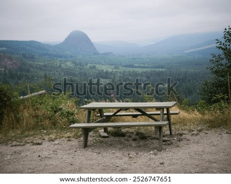 Picnic table with View of Walker Valley mountains near Mount Vernon in Western Washington with mist and purple flowers