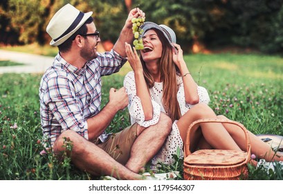 Picnic time. Young couple eating grapes and enjoying in picnic. Love and tenderness, dating, romance, lifestyle concept