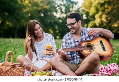 Picnic time. Young couple having fun on picnic in the park. Love and tenderness, dating, romance, lifestyle concept - Powered by Shutterstock