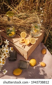 Picnic In The Wheat Field. Lemons, Apricots, A Wooden Table On A Blanket. Lemonade In Glasses. Aesthetics Of Breakfast In Nature. Outdoor Recreation. No People